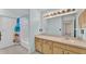 Bathroom featuring light blue walls, vanity, large mirror, and a shower/tub at 6244 Napa Dr, Lakeland, FL 33813