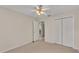 Inviting bedroom showcasing carpet, a ceiling fan, closet, and an open door for seamless flow at 6244 Napa Dr, Lakeland, FL 33813