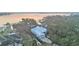 Waterfront home boasting a serene lakeside view surrounded by trees, complemented by a long driveway at 739 Swann Dr, Lakeland, FL 33809