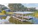 Aerial view of a home with a private dock, a well-maintained lawn, and lush landscaping extending to the waterfront at 739 Swann Dr, Lakeland, FL 33809