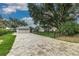 Paver driveway leading to a modern home with a well-manicured lawn, complemented by a black iron fence at 739 Swann Dr, Lakeland, FL 33809