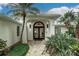 Close-up of the front entry with decorative glass doors, elegant lighting, and manicured landscaping at 739 Swann Dr, Lakeland, FL 33809
