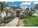 Stunning home exterior featuring a brick walkway, lush landscaping, and a covered entryway with ornate glass doors at 739 Swann Dr, Lakeland, FL 33809