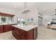 Spacious kitchen with cherry cabinetry, expansive island with bar seating, and a seamless transition to the living area at 739 Swann Dr, Lakeland, FL 33809