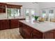Bright kitchen featuring cherry cabinets, a large island with a white countertop, and views of the pool at 739 Swann Dr, Lakeland, FL 33809