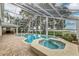 Enclosed pool and spa area with brick pavers and partial outdoor kitchen at 739 Swann Dr, Lakeland, FL 33809