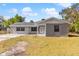 Newly renovated home with gray brick exterior, landscaped yard, and a covered porch at 815 N Hendry Ave, Fort Meade, FL 33841