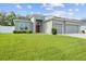 Gray house with two-car garage, lush lawn and red door at 8218 Wilder Loop, Lakeland, FL 33809