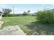 Large backyard with grassy area, palm trees, and a paved patio at 1007 Canary S Cir, Lakeland, FL 33809