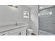 Bright bathroom featuring a modern vanity, toilet, and a glass-enclosed shower with gray tiling and a window at 105 3Rd Eloise St, Winter Haven, FL 33880
