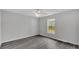 A simple bedroom with gray floor is bathed in natural light from a window at 105 3Rd Eloise St, Winter Haven, FL 33880