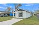 Charming single-story home with white stucco and black trim, featuring a well-maintained front lawn and a modern design at 105 3Rd Eloise St, Winter Haven, FL 33880