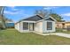 Charming single-story home with white stucco and black trim, featuring a well-maintained front lawn and a modern design at 105 3Rd Eloise St, Winter Haven, FL 33880