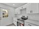 Modern kitchen features stainless steel appliances, white cabinets, and light countertops with exterior door at 105 3Rd Eloise St, Winter Haven, FL 33880