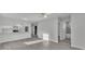 Bright open-concept living space with modern gray flooring, white cabinets, and stainless steel appliances at 105 3Rd Eloise St, Winter Haven, FL 33880