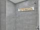 Modern shower features gray tile walls, a built-in window, and sleek fixtures in a well-lit space at 105 3Rd Eloise St, Winter Haven, FL 33880