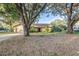 Charming home exterior with lush trees and long driveway at 1116 E Devonshire Ln, Lakeland, FL 33813