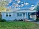 Quaint single-story home features a covered porch, blue siding, and a well-maintained front yard with a carport at 1128 Olive St, Lakeland, FL 33815