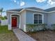 Charming single-story home featuring a vibrant red front door and manicured landscaping at 1141 N Hampton Dr, Davenport, FL 33897