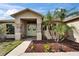 Charming front entrance with decorative wreaths, stone pillars, and colorful landscaping at 1640 Taylor Landing Dr, Bartow, FL 33830