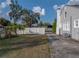 Spacious backyard with a large grassy area, concrete driveway, and white fence for privacy and outdoor enjoyment at 1841 Casco St, Lakeland, FL 33801