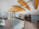 Bedroom showcasing exposed beams, a cozy bed, and views to the staircase at 1841 Casco St, Lakeland, FL 33801