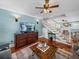 Stylish living room with a wooden staircase, hardwood floors, a dresser with TV, and a coffered ceiling at 1841 Casco St, Lakeland, FL 33801