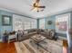 Cozy living room with large windows, a ceiling fan, area rug, and a comfortable gray sectional sofa at 1841 Casco St, Lakeland, FL 33801