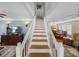 Staircase with white railings, wooden steps, and open view to dining and living areas at 1841 Casco St, Lakeland, FL 33801