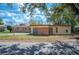 Charming single-story home featuring a brick and stucco exterior with a well-maintained front yard and mature shade trees at 1925 John Arthur Way, Lakeland, FL 33803