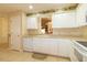Well-lit kitchen with white cabinetry, tile flooring, and charming floral wallpaper at 1961 Rocky Pointe Dr, Lakeland, FL 33813