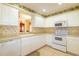 Well-lit kitchen featuring white cabinetry and appliances with a decorative wallpaper border at 1961 Rocky Pointe Dr, Lakeland, FL 33813