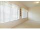 Bright living room featuring large windows with vertical blinds and neutral carpeting at 1961 Rocky Pointe Dr, Lakeland, FL 33813