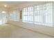 Bright and airy living room with white walls, neutral carpeting, and large windows with vertical blinds at 1961 Rocky Pointe Dr, Lakeland, FL 33813