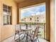 Balcony with a table and chairs overlooking the building and greenery with natural sunlight at 205 Terrace Ridge Cir # 205, Davenport, FL 33896