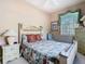 Comfortable bedroom featuring queen sized bed, a nightstand with lamp and a large window with natural lighting at 205 Terrace Ridge Cir # 205, Davenport, FL 33896