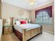 Comfortable bedroom with a decorative mirror, side tables, and a soothing color palette at 205 Terrace Ridge Cir # 205, Davenport, FL 33896