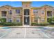 Two-story apartment building featuring a covered entryway, balconies, and accessible parking at 205 Terrace Ridge Cir # 205, Davenport, FL 33896