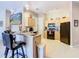 Bright kitchen featuring breakfast bar, light cabinetry, black appliances and a TV, perfect for cooking at 205 Terrace Ridge Cir # 205, Davenport, FL 33896