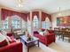 Comfortable living room with plush red sofas, decorative pillows, and natural light from large windows at 205 Terrace Ridge Cir # 205, Davenport, FL 33896