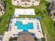 Aerial view of a large pool with lounge chairs, umbrellas, and a nearby sand volleyball court at 205 Terrace Ridge Cir # 205, Davenport, FL 33896