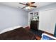 Simple bedroom with wood floors, a ceiling fan, and a dark wood dresser, offering storage and comfort at 2160 Country Manor St, Bartow, FL 33830