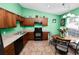 A bright eat-in kitchen with wooden cabinets and a view to the backyard at 2160 Country Manor St, Bartow, FL 33830