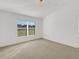 Sunlit bedroom features neutral carpet, light walls, and a large window with blinds at 2454 Harrison Place Blvd, Lakeland, FL 33810