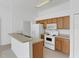 Efficient kitchen features white appliances, wood cabinets, and a breakfast bar at 2454 Harrison Place Blvd, Lakeland, FL 33810
