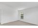 Minimalist room with neutral carpet and white walls, accentuated by a window with a view of the neighborhood at 2454 Harrison Place Blvd, Lakeland, FL 33810