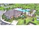 Aerial view of the community pool, clubhouse and lush landscaping surrounded by green spaces and modern homes at 2816 Ivy Lake Ct, Lakeland, FL 33811