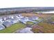 A high-angle shot captures a community near a peaceful lake, with visible railway tracks in the distance at 2816 Ivy Lake Ct, Lakeland, FL 33811
