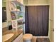Bathroom featuring granite countertop, tiled floors, dark shower curtain and decorated shelves at 2816 Ivy Lake Ct, Lakeland, FL 33811