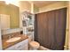 Bathroom featuring granite countertop, tiled floors, dark shower curtain and decorated shelves at 2816 Ivy Lake Ct, Lakeland, FL 33811
